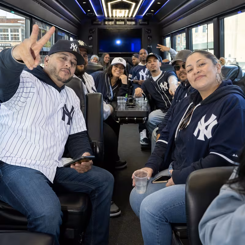 Group boarding a white charter bus for Sporting Event Transportation transportation in Bronx