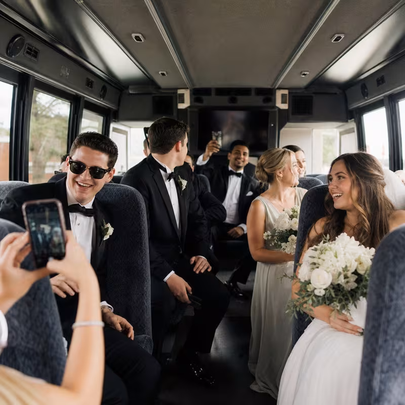 Group boarding a white charter bus for Wedding Transportation transportation in Bronx